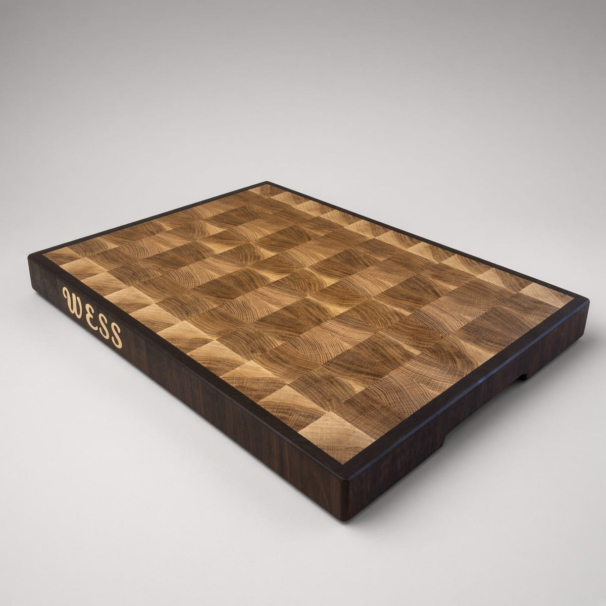White oak end grain cutting board with a Peruvian walnut border and a WESS side name inlay
