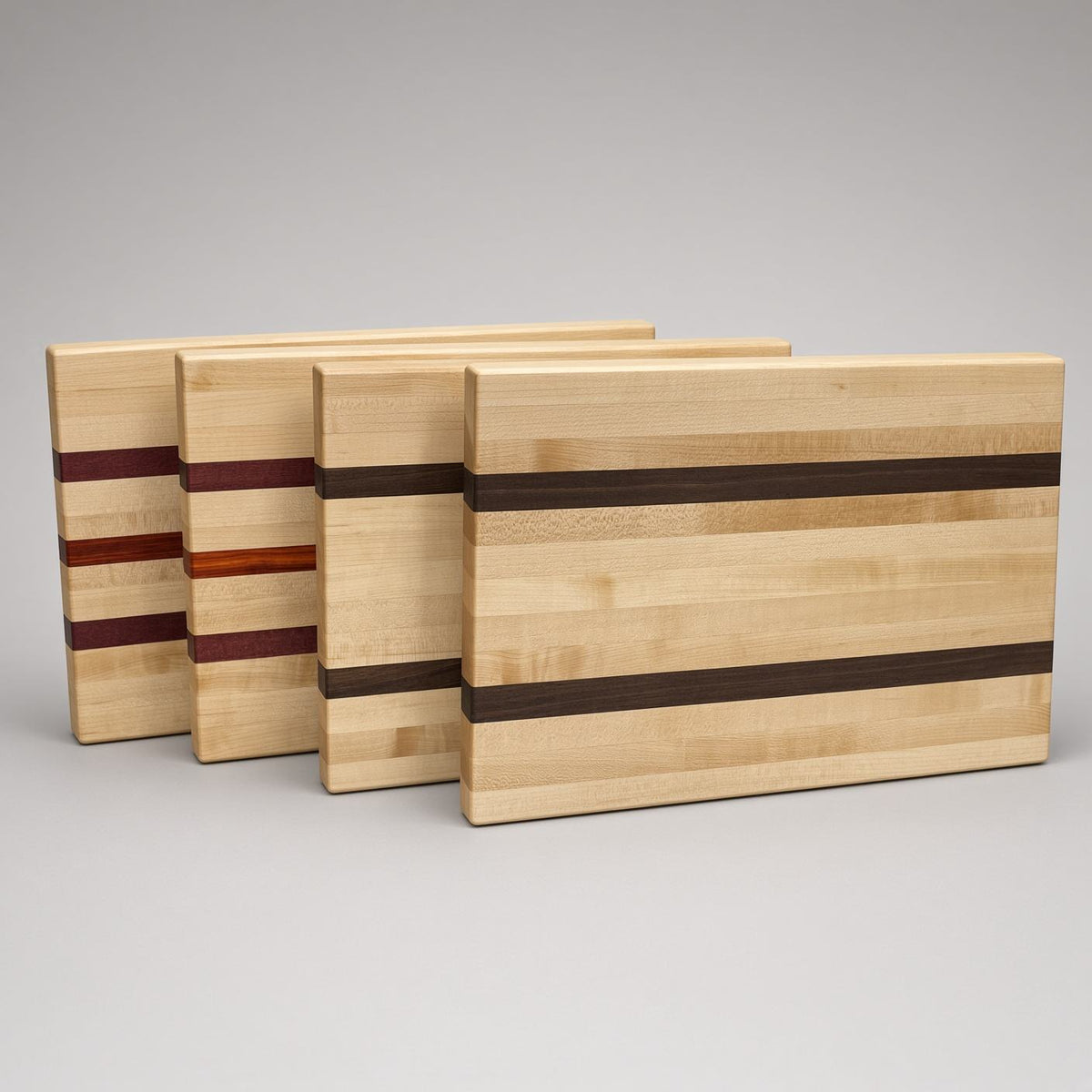 Maple edge grain cutting boards with purpleheart, padauk and wenge stripes