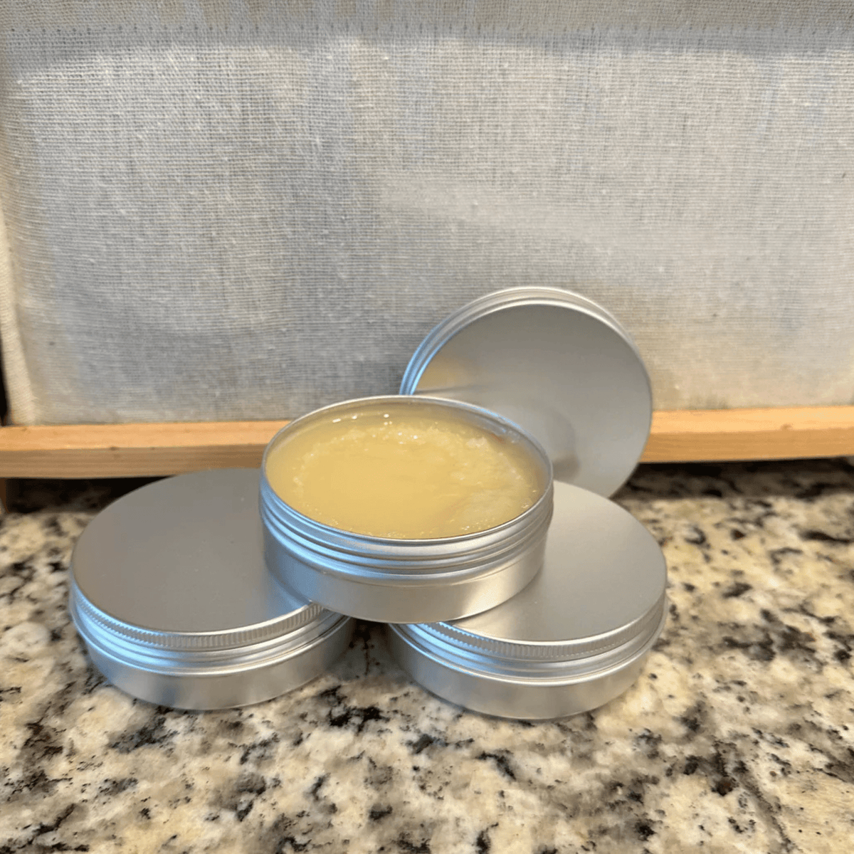 Board Butter cutting board wax in 4 oz tins, one open